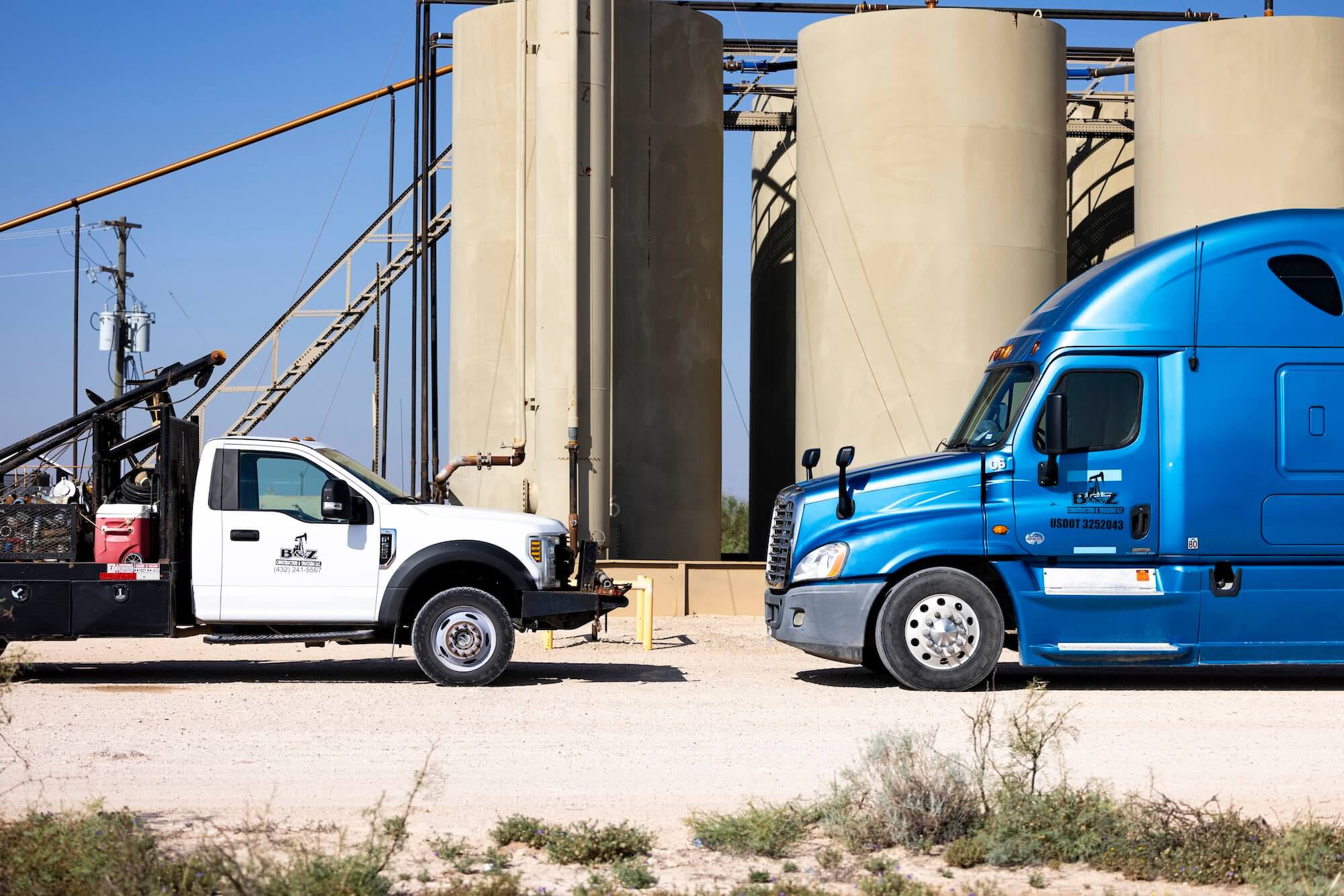 blue-semi-and-white-service-truck-at-tanks